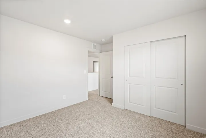 Neutral tone carpeting with white baseboards