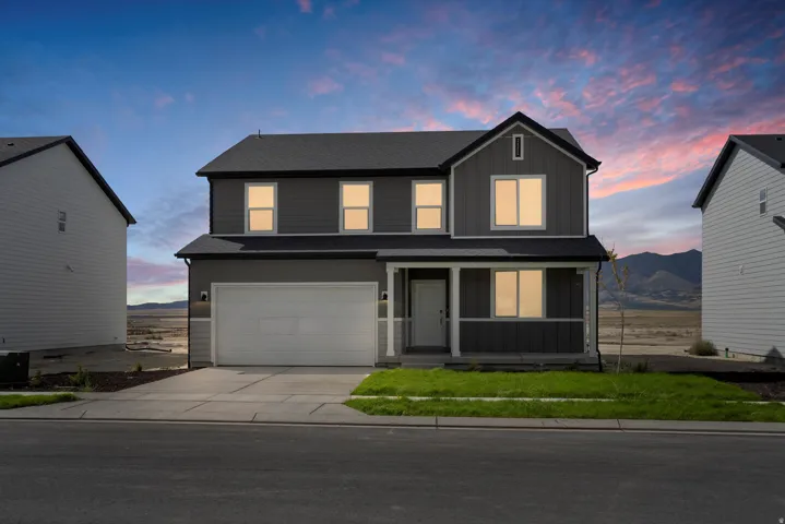 Contemporary two-story residence featuring a dark gray facade with white trim accents and a covered front porch