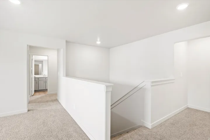 Upper-level landing featuring carpeted flooring and recessed lighting