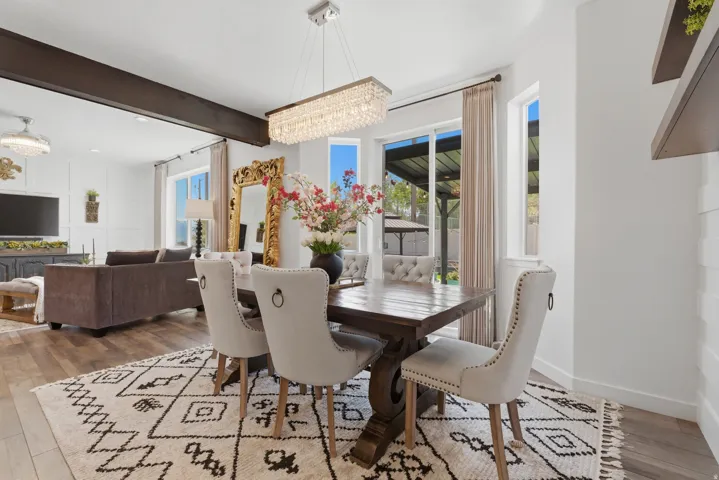 Dining area featuring a wood-finish table, upholstered chairs, and a crystal chandelier