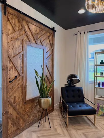 Custom wood barn door with unique geometric detailing and frosted glass panel, set against a dark ceiling and light walls