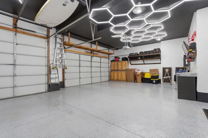 Spacious garage featuring two overhead doors and light gray epoxy flooring