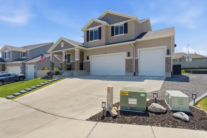 Two-story residence featuring a two-car garage, stone accents, and a covered porch entry