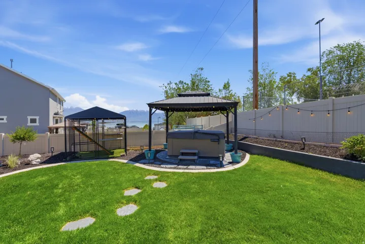 Expansive backyard featuring a lush lawn and a stone paver pathway