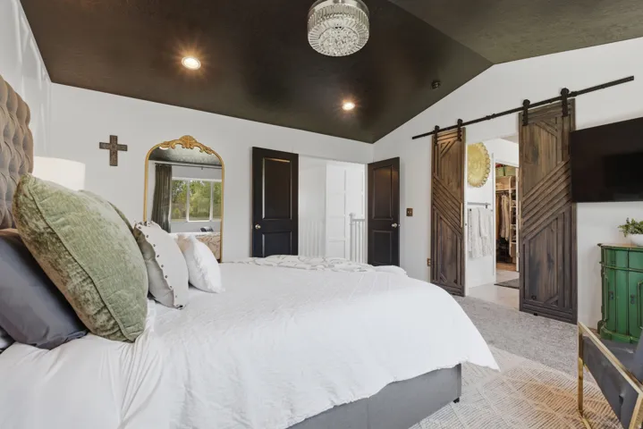 Vaulted ceiling featuring recessed lighting and a crystal chandelier