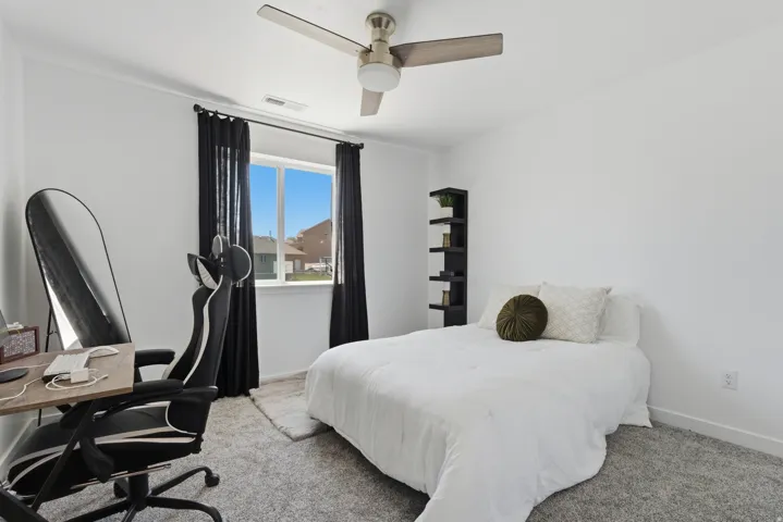 Neutral white walls with a window featuring black drapes