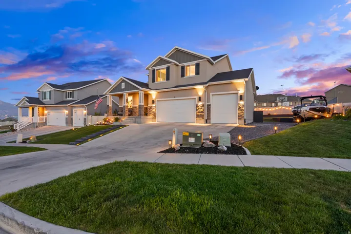 Two-story stucco and stone exterior featuring an attached two-car garage