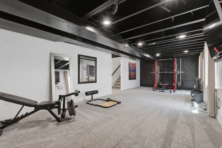 Spacious room featuring light gray carpeting and white walls
