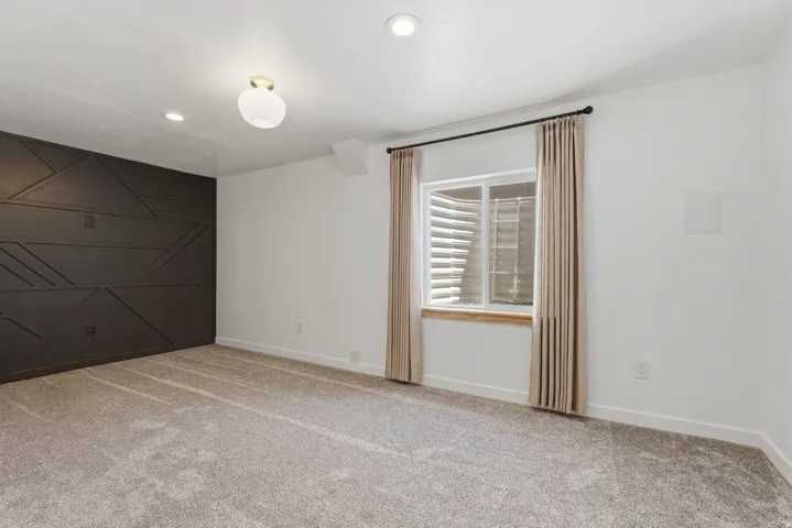 Accent wall with geometric paneling, recessed lighting, and a modern ceiling fixture