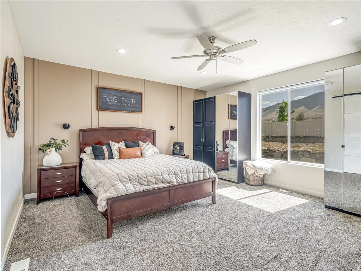 Spacious bedroom featuring neutral carpeting, a large window, and recessed lighting