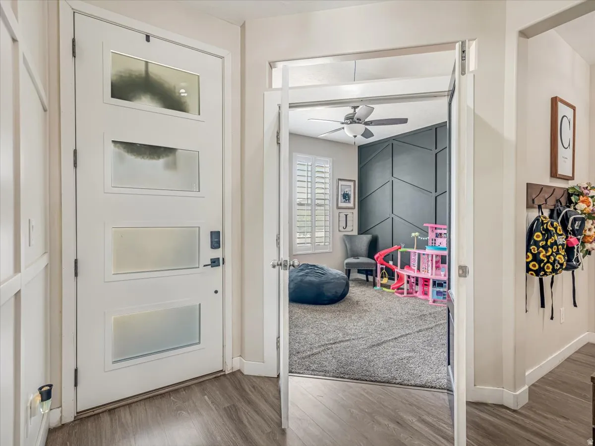 Entryway featuring a modern door with multiple frosted glass panels and wood-finish flooring