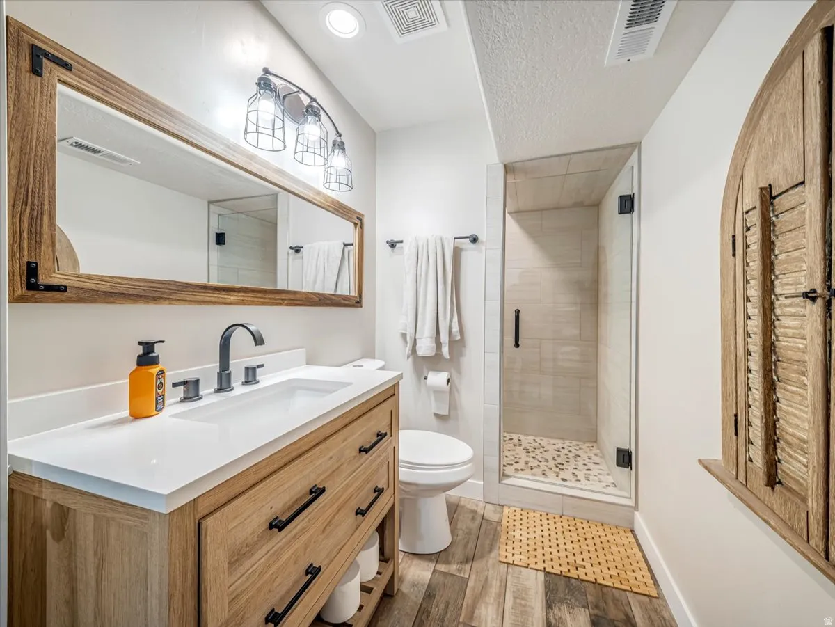 Bathroom featuring a wood-finish vanity with a white countertop, matte black faucet, and a rectangular mirror with a wood frame