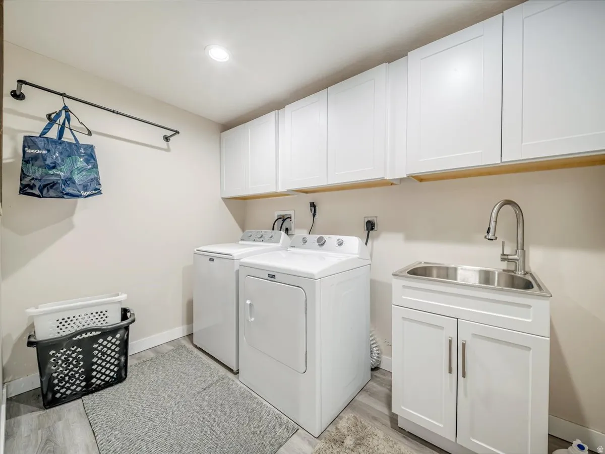 Dedicated laundry room featuring wood-finish flooring and recessed lighting