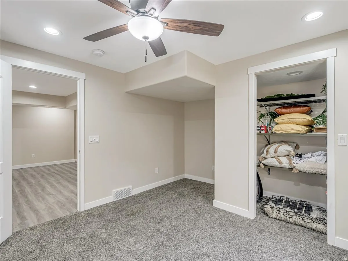 Interior space featuring neutral wall tones and a ceiling fan with integrated lighting