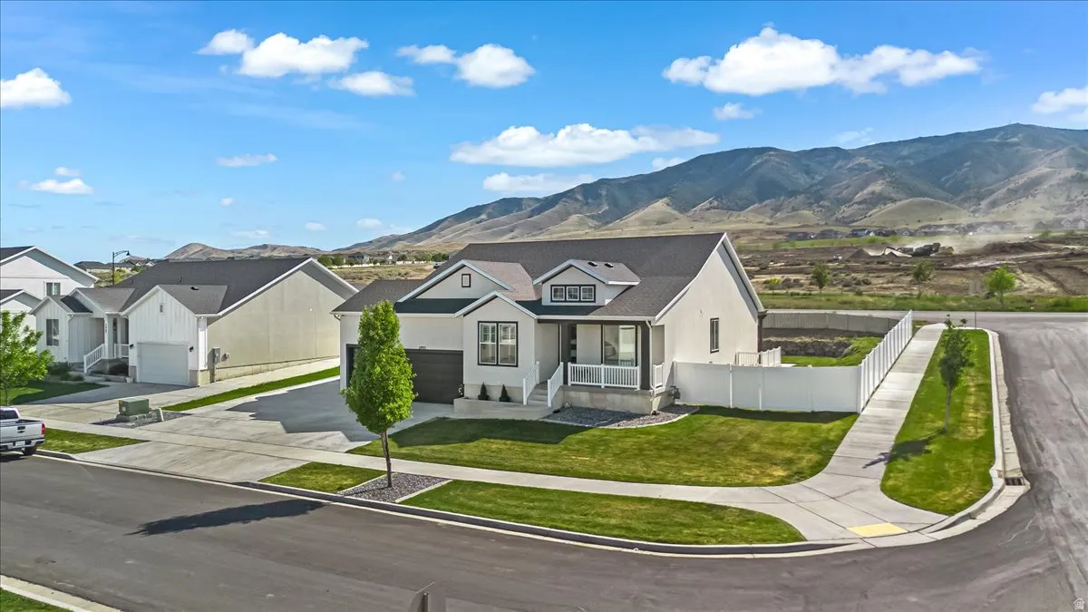 Contemporary-style residence featuring a prominent front-facing gable, a dark asphalt shingle roof, and light-toned stucco siding