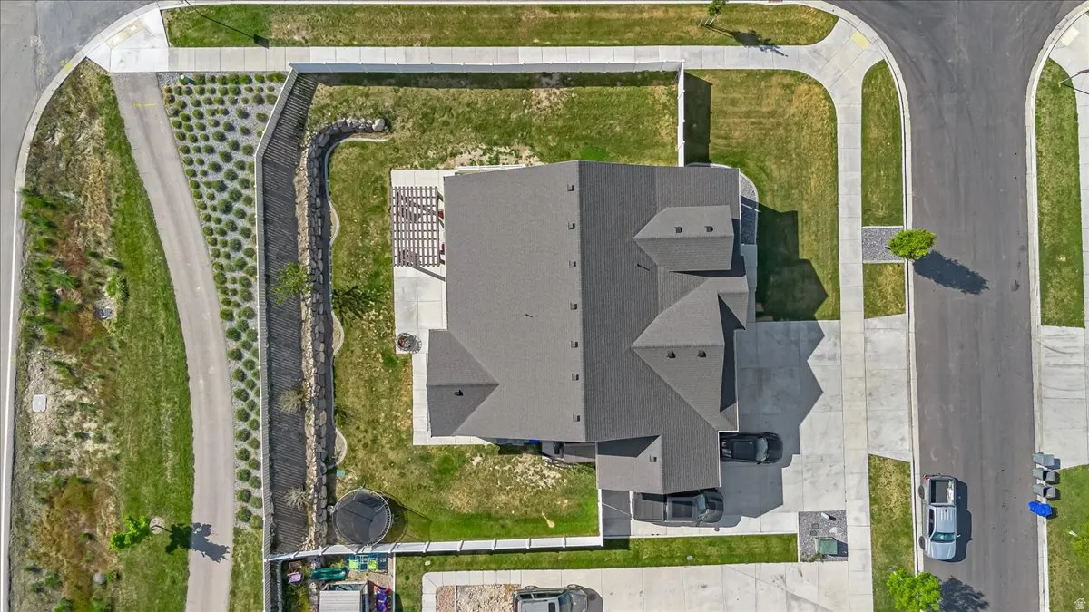 Aerial property view featuring a dark shingle roof and a concrete driveway