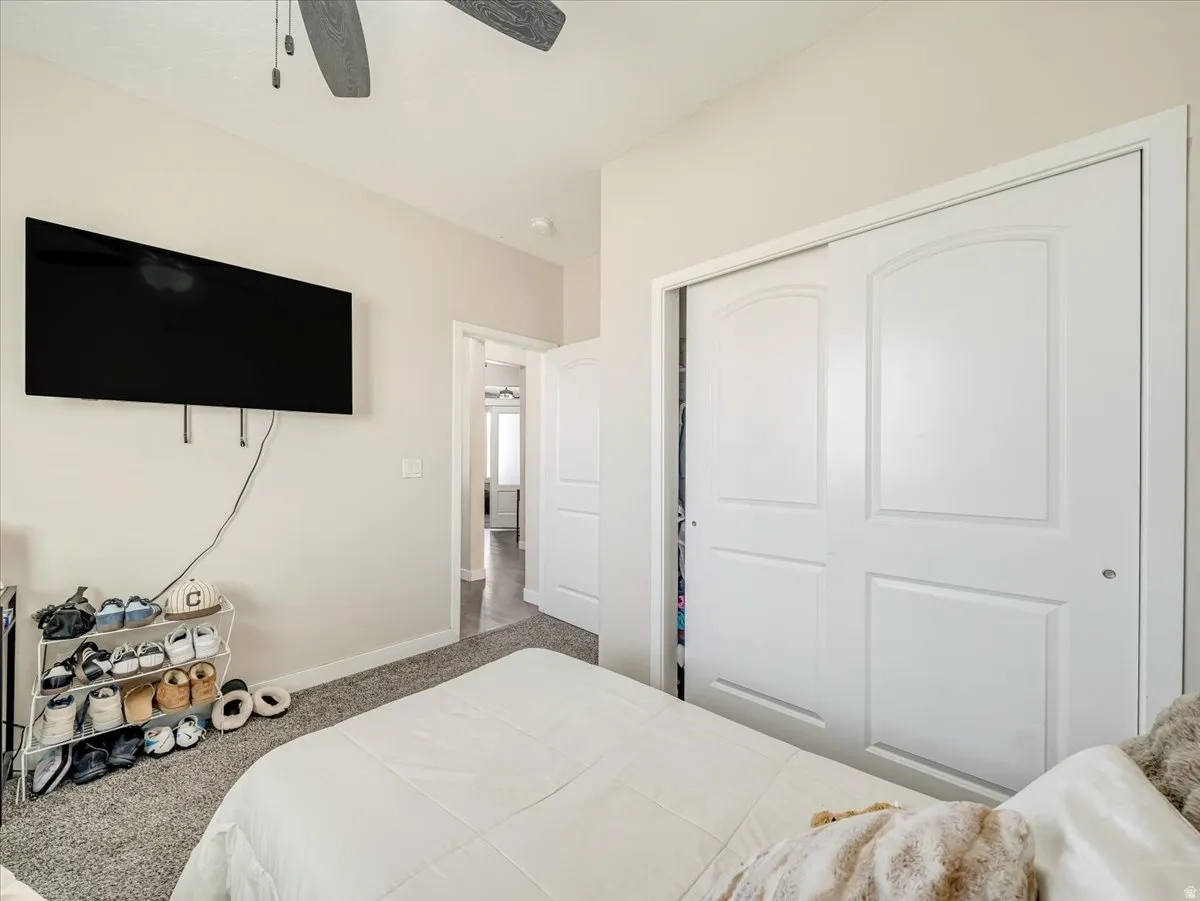 Gray carpet flooring, white walls, white trim, and a white six-panel bi-fold closet door