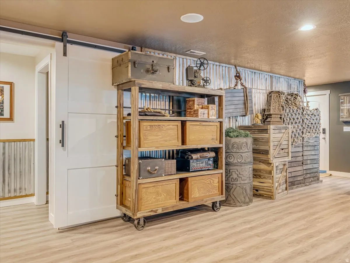 Light wood-finish flooring with a white barn door