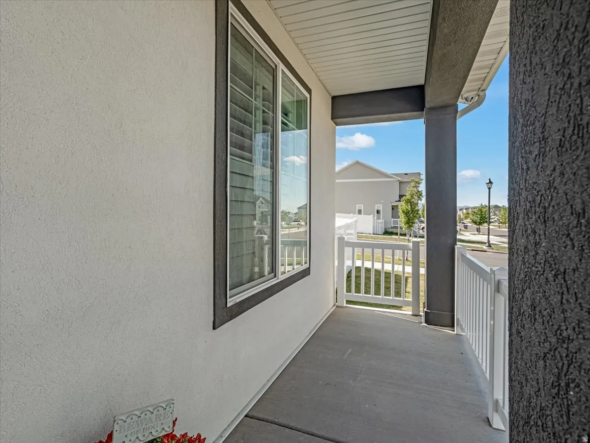 Covered front porch with concrete flooring and white vinyl railing