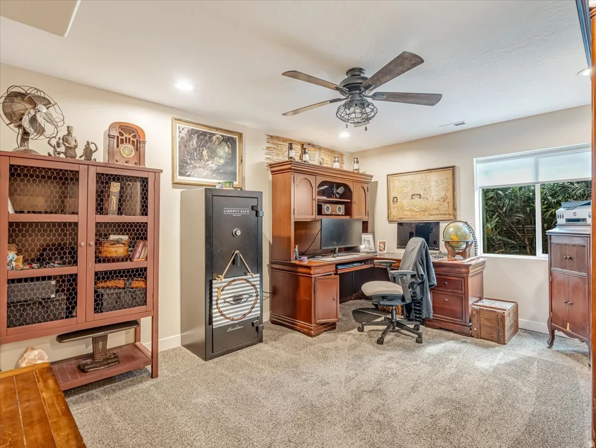 Spacious home office featuring carpet flooring, recessed lighting, a ceiling fan, and a large window