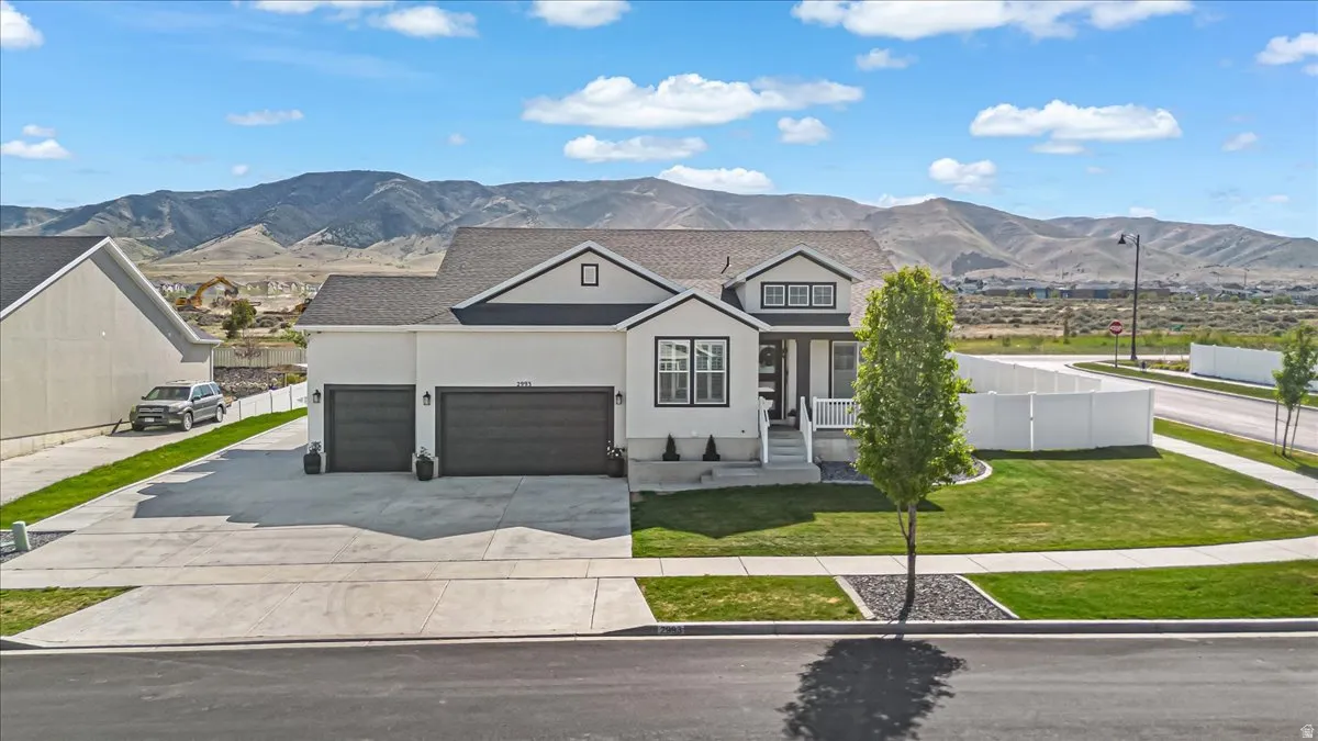 Modern traditional exterior featuring a two-car garage, white siding with dark trim accents, and a covered front entry