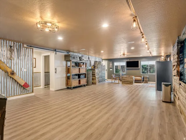 Spacious room featuring wood-finish flooring and a barn door entry