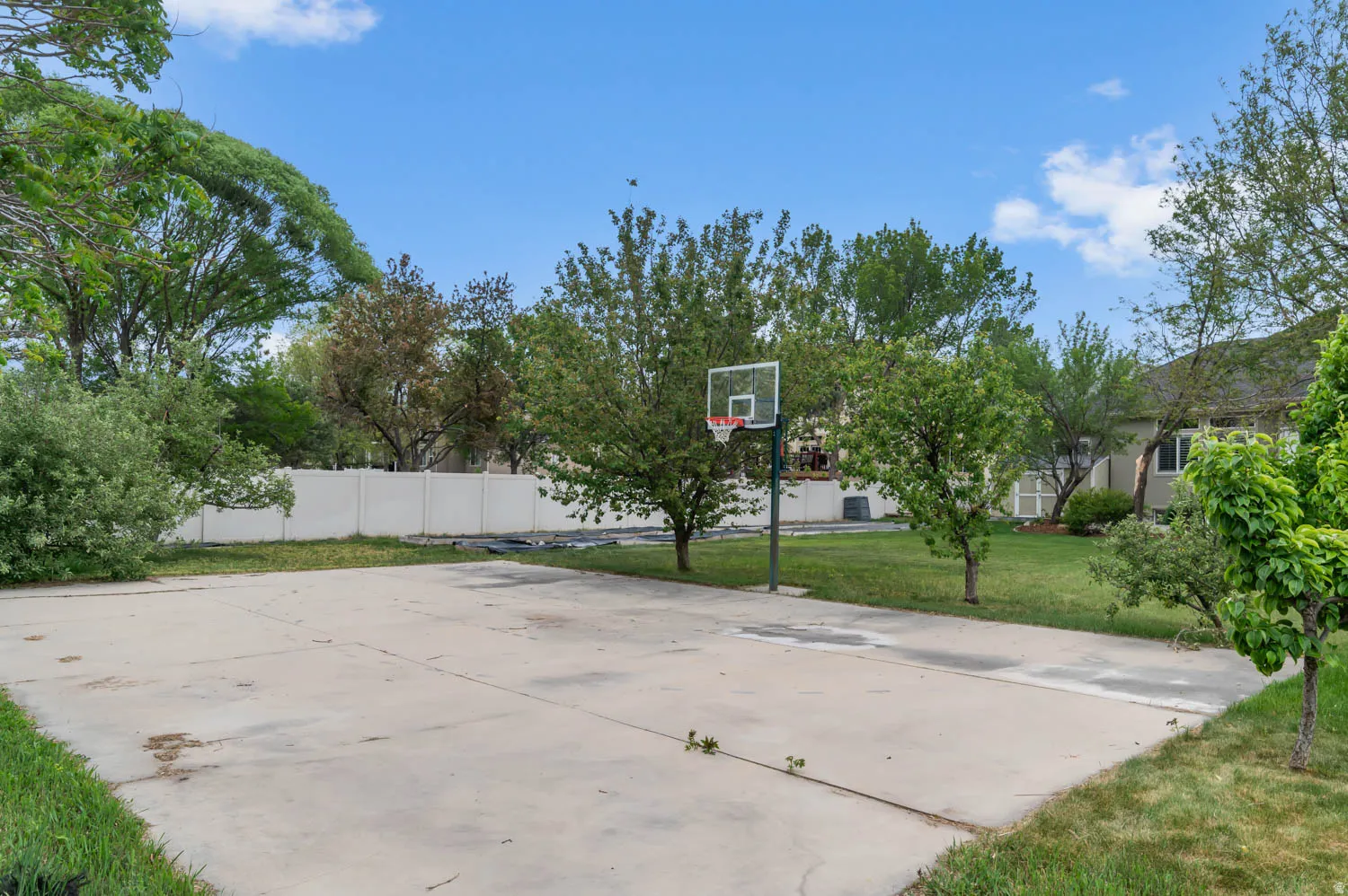 Concrete sport court featuring an adjustable basketball hoop