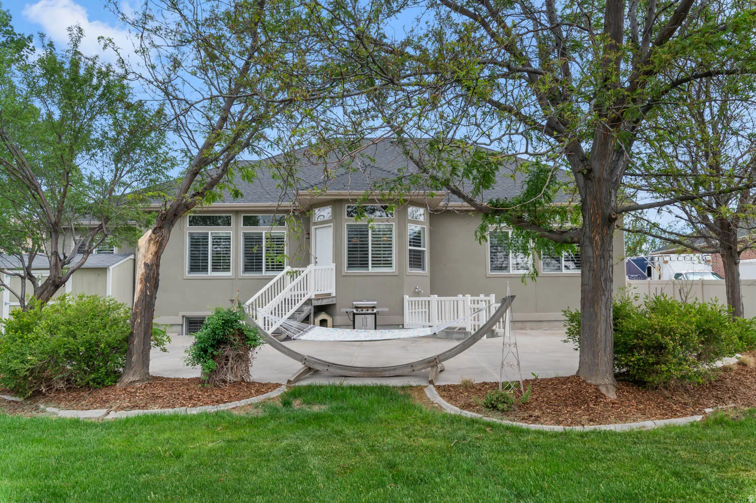 Expansive rear patio featuring a concrete surface and white railing