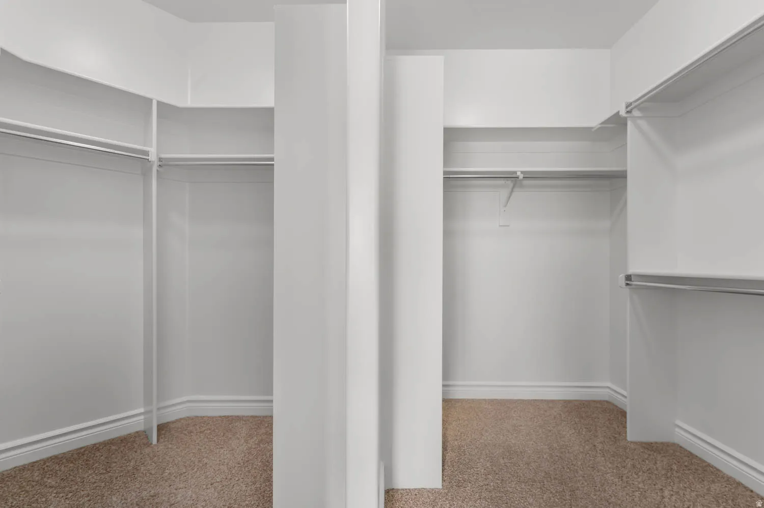 Walk-in closet featuring extensive built-in shelving and hanging rods