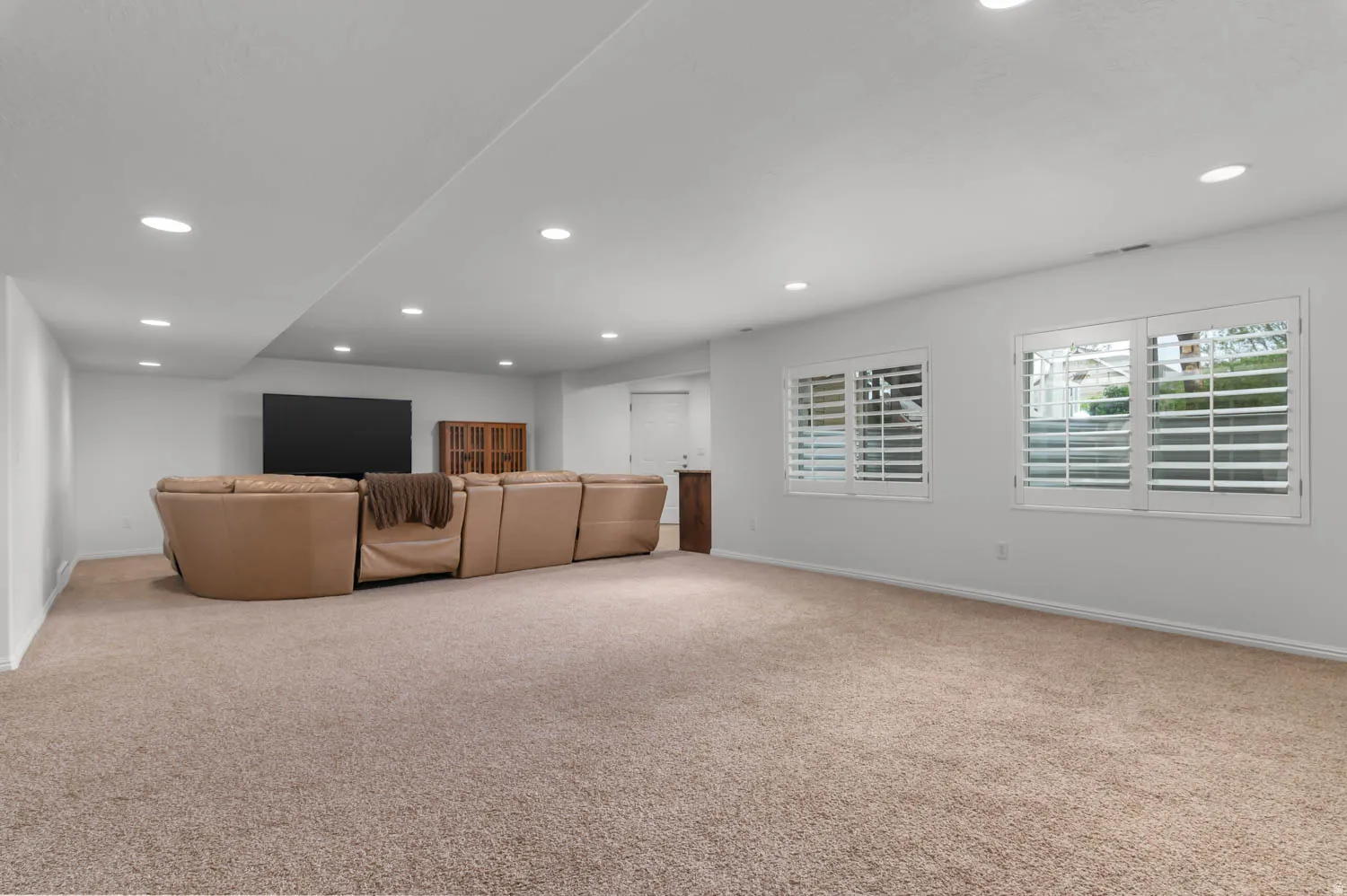 Spacious room featuring plush carpet flooring and recessed lighting