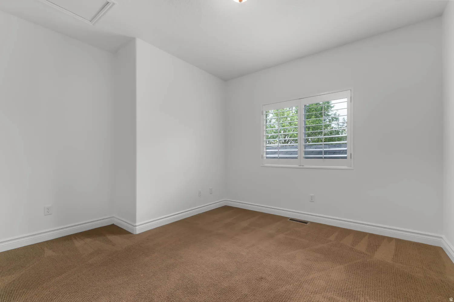 Bright interior with a window featuring white plantation shutters