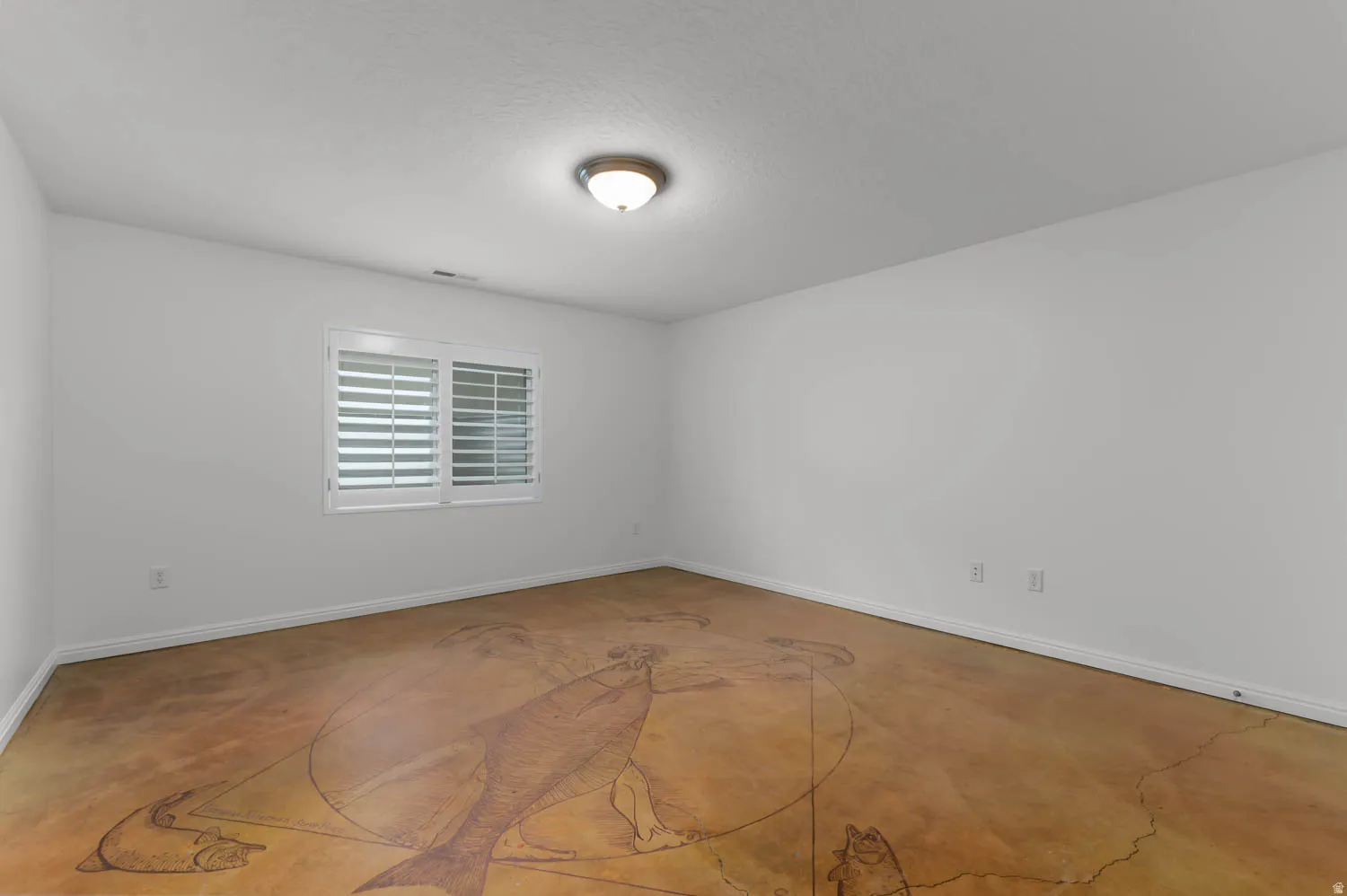 Spacious room featuring a unique patterned floor, white walls, and a window with plantation shutters