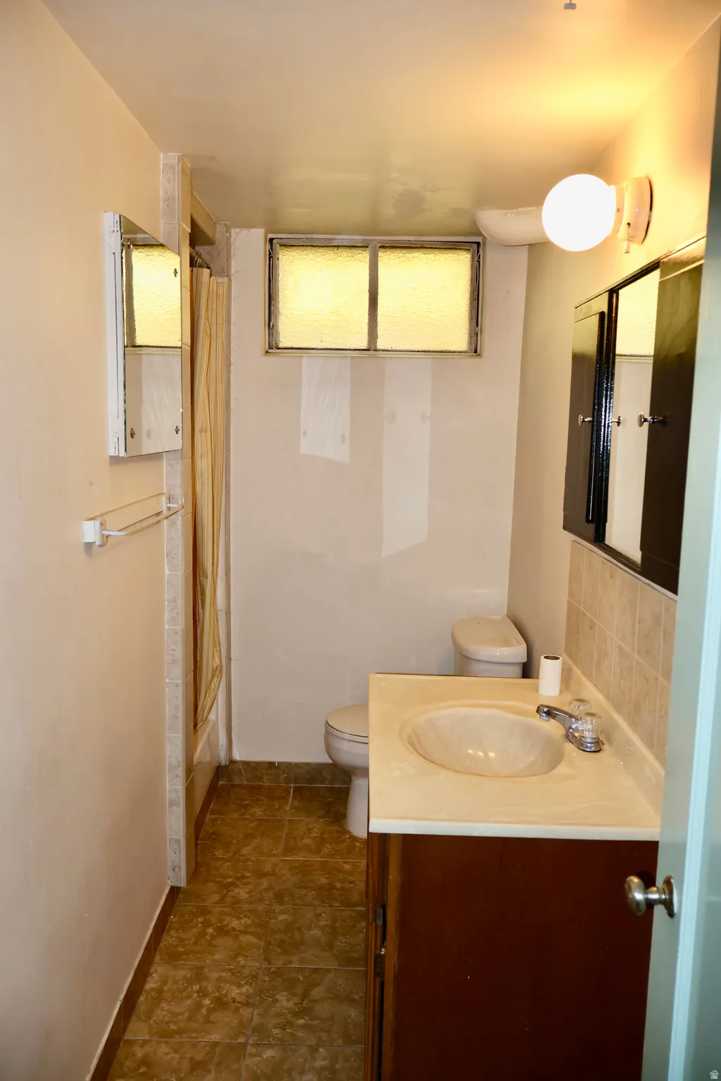 Bathroom featuring a vanity with an integrated sink, a toilet, and a bathtub with a shower