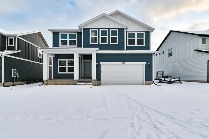 Two-story residence featuring a dark blue siding facade with white trim accents