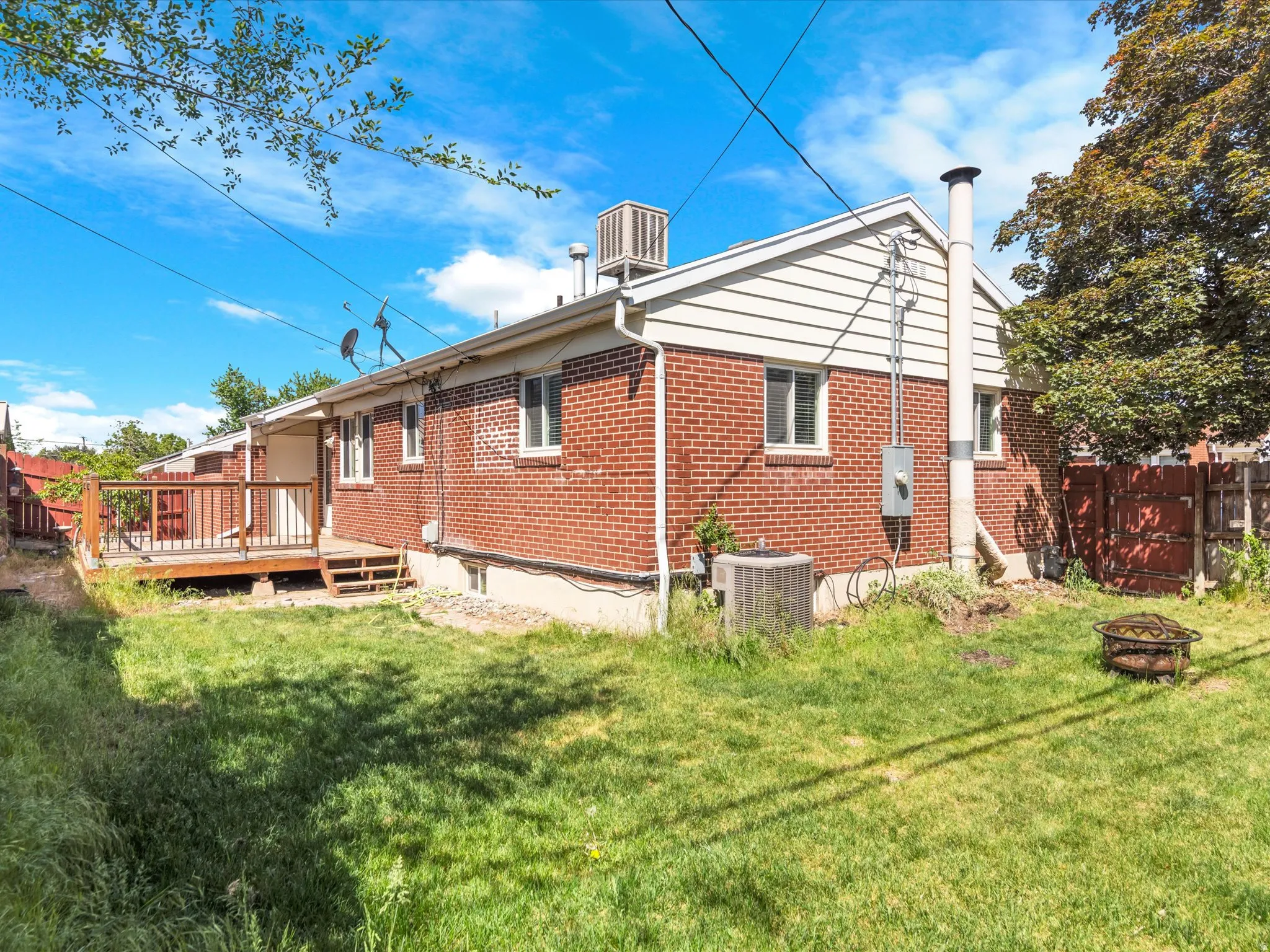 Brick exterior with white siding accents and a wooden deck