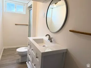 Modern bathroom featuring a white vanity with integrated sink, brushed nickel faucet, and a round wall-mounted mirror