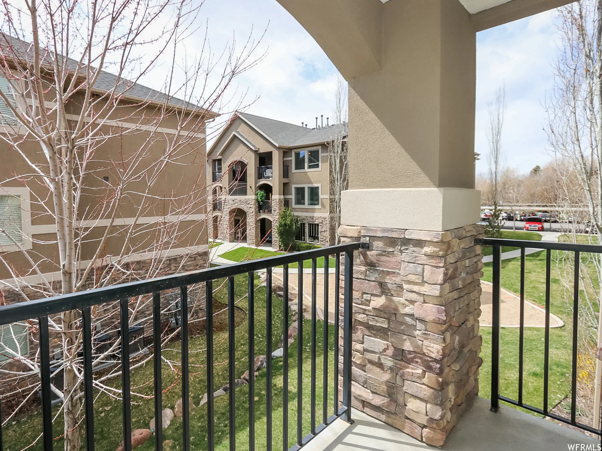 Balcony with stacked stone pillar and black metal railing