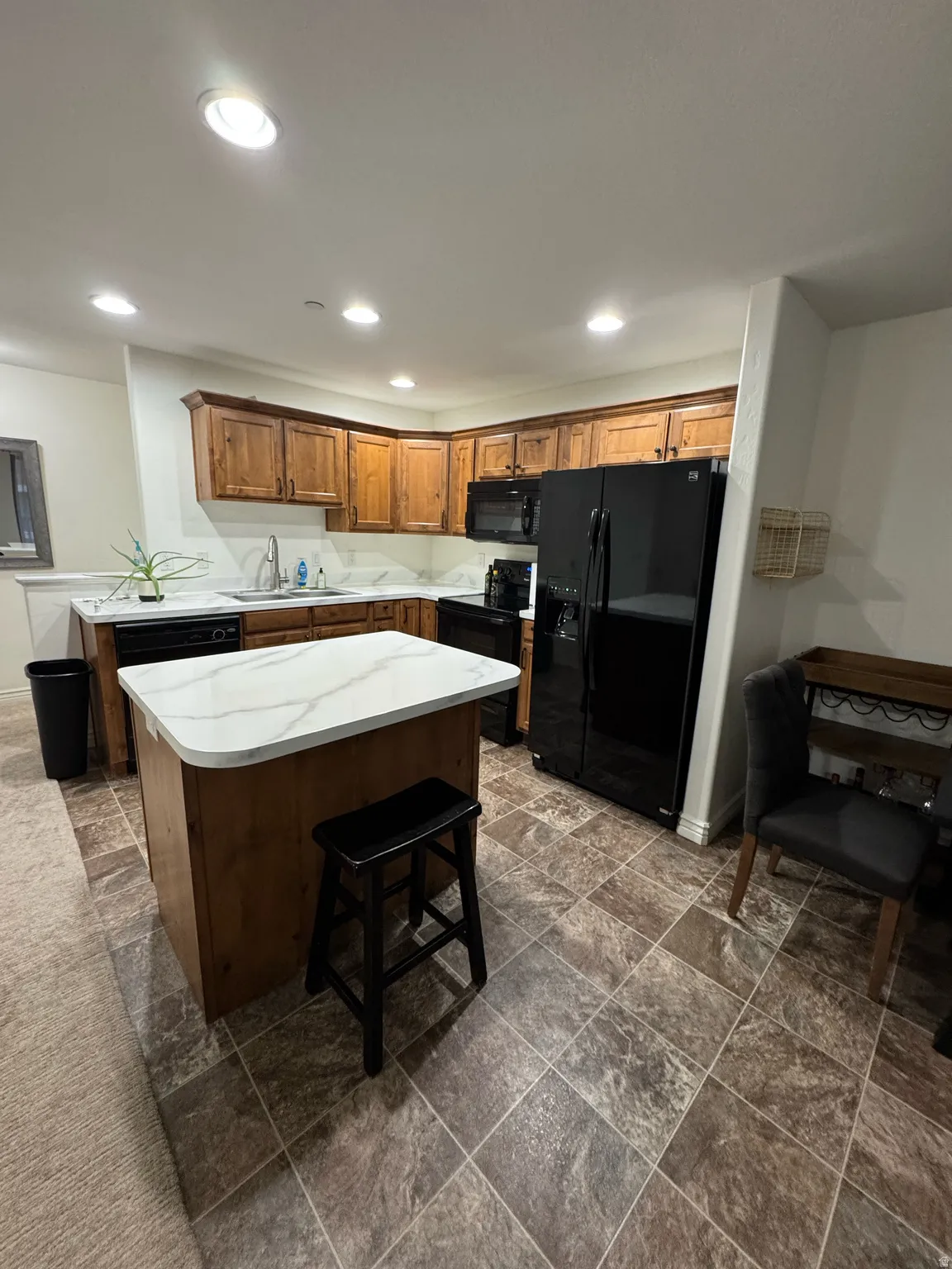 Kitchen featuring a central island with a white marble-look countertop