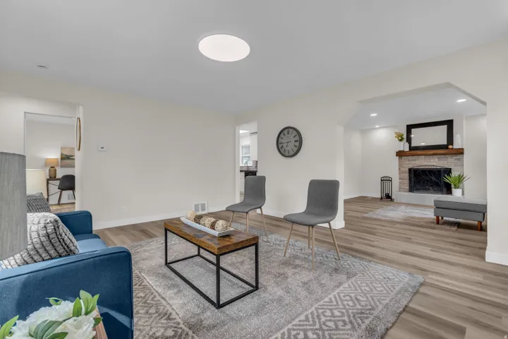 Living area featuring light-toned wood-finish flooring, recessed lighting, and a prominent arched entryway