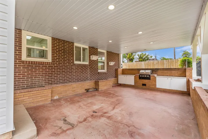 Covered patio featuring an outdoor kitchen with integrated grill and extensive cabinetry