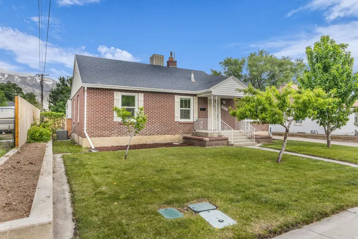Brick exterior featuring a gabled roof and white window trim