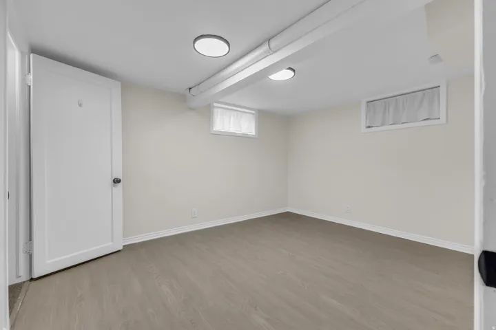 Finished room featuring wood-finish flooring, white baseboards, and two windows