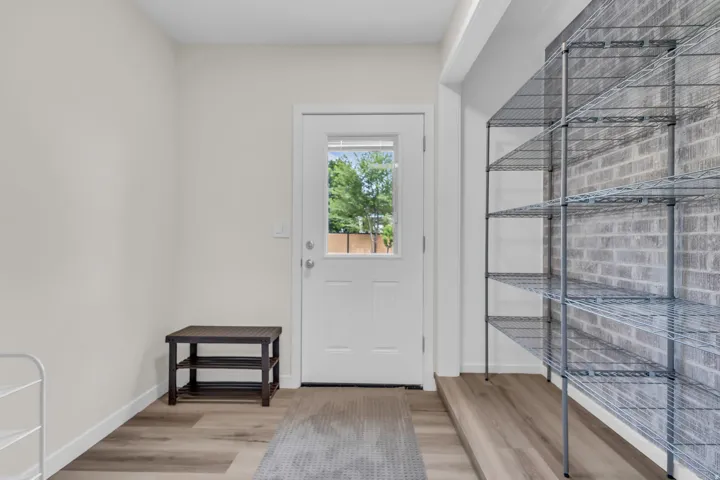 Entryway featuring wood-finish flooring and a white paneled door with a clear glass insert