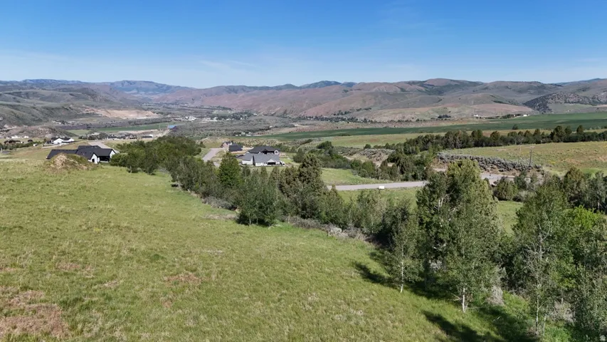 Expansive green hillsides and distant mountainous terrain create a pastoral setting
