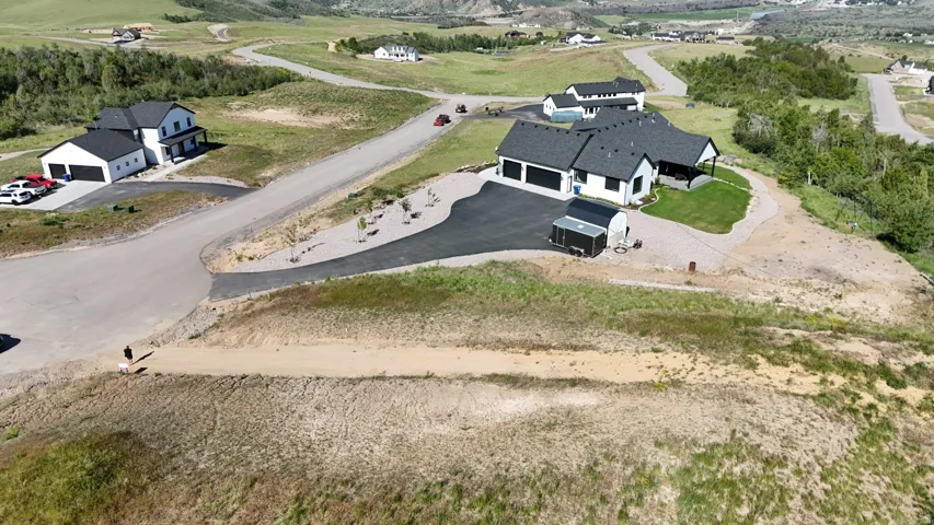 Contemporary white exterior with a dark shingle roof, two-car garage, paved driveway, and covered front porch