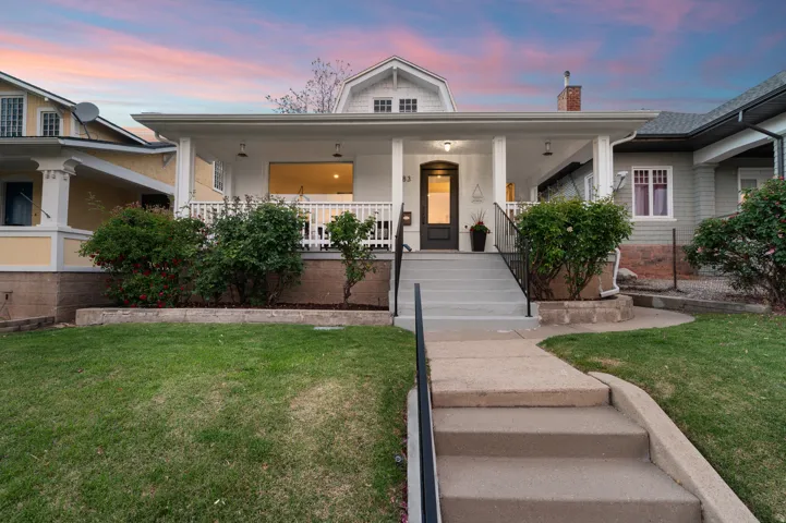 Craftsman-style home featuring a covered front porch with white railings and columns