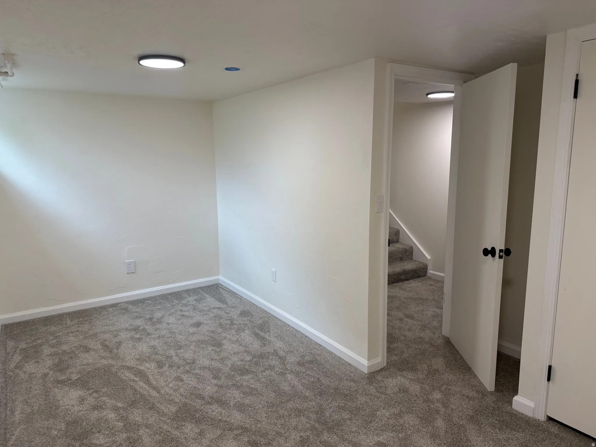 Neutral-toned walls complement plush grey carpeting throughout this space