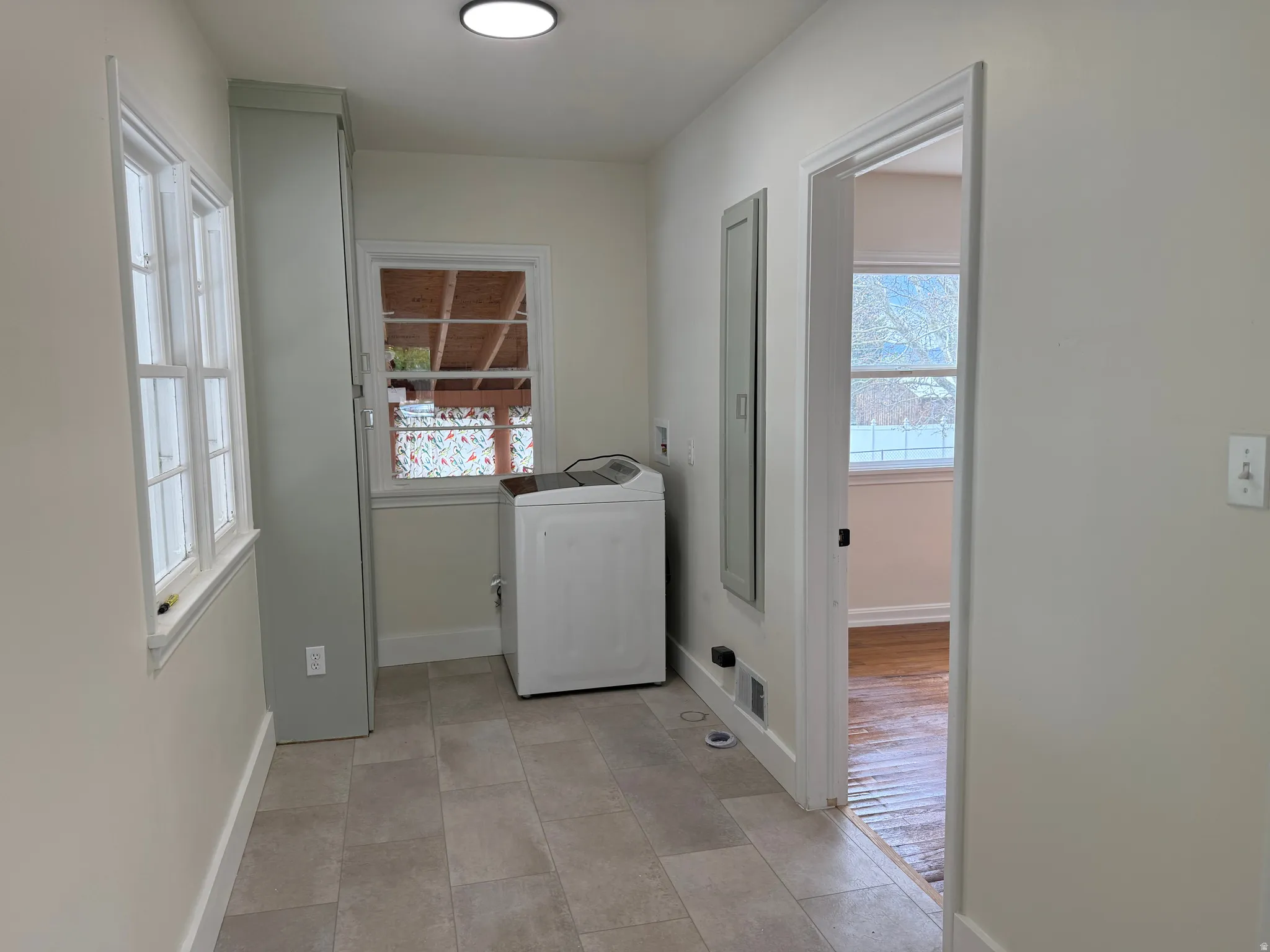 Bright utility area featuring tiled flooring