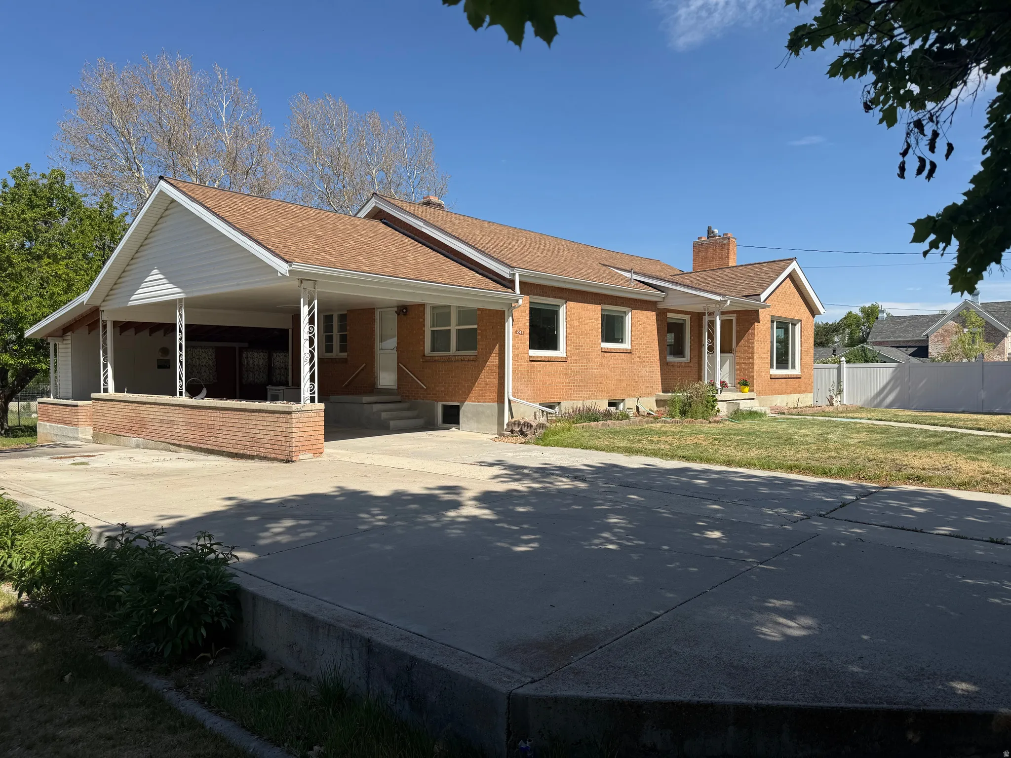 Brick exterior featuring white trim and a brown shingle roof