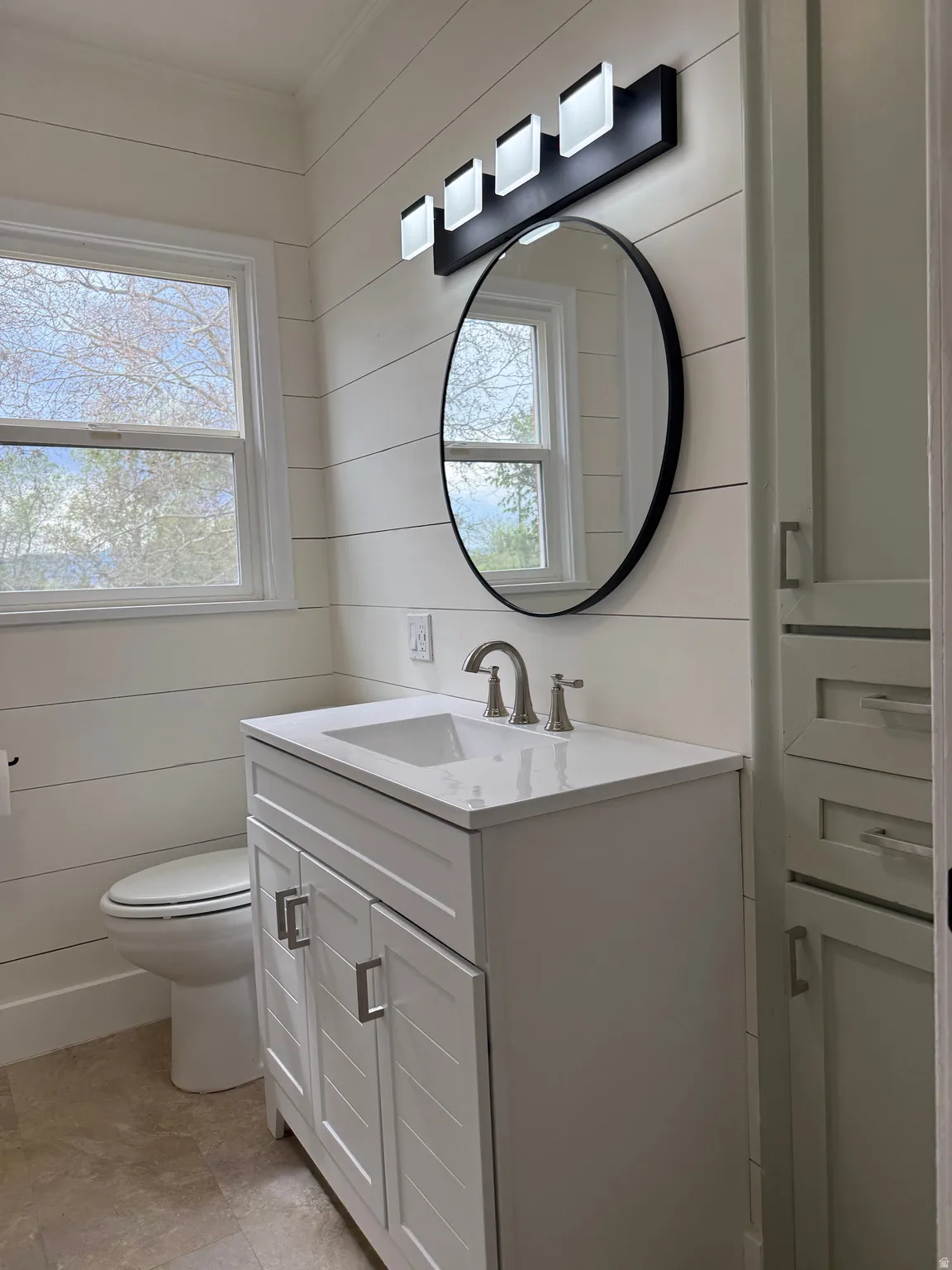 Modern bathroom featuring a white vanity with a rectangular undermount sink, a stone-finish countertop, and brushed nickel fixtures